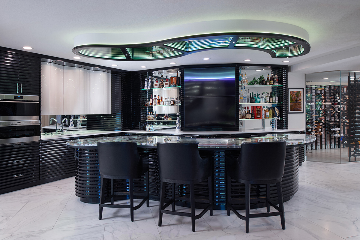 Kleweno custom basement bar and wine cellar Premium stone countertops with curved edges in a custom home bar