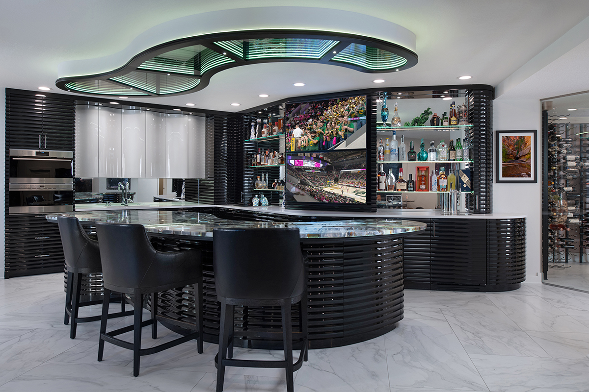 Kleweno custom basement bar and wine cellar Curved waterfall bar island with seating for entertaining guests