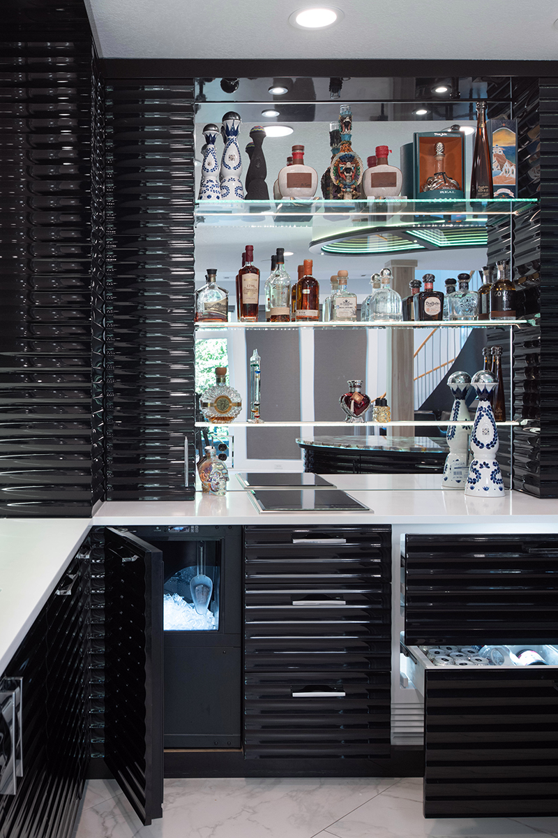 Kleweno custom basement bar and wine cellar Illuminated display shelving showcasing glassware and spirits