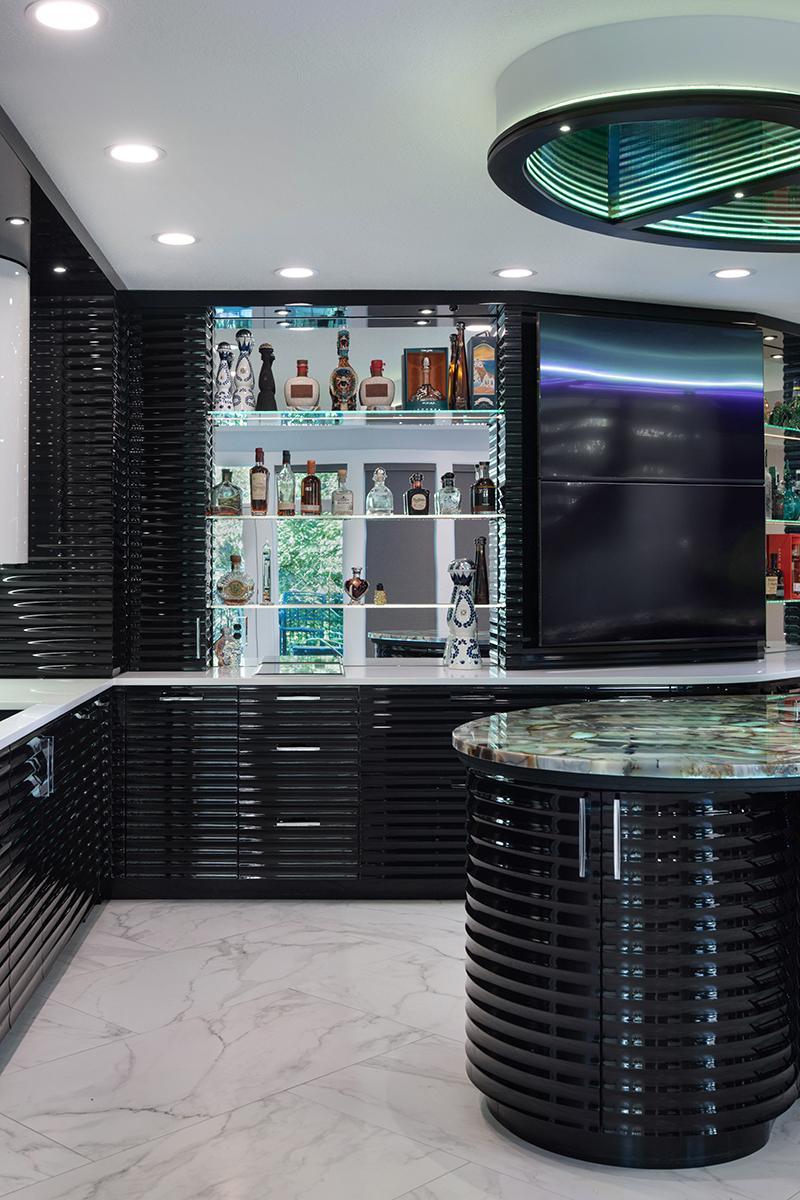 Kleweno custom basement bar and wine cellar Custom back bar with illuminated shelving, beverage storage, and display cabinetry