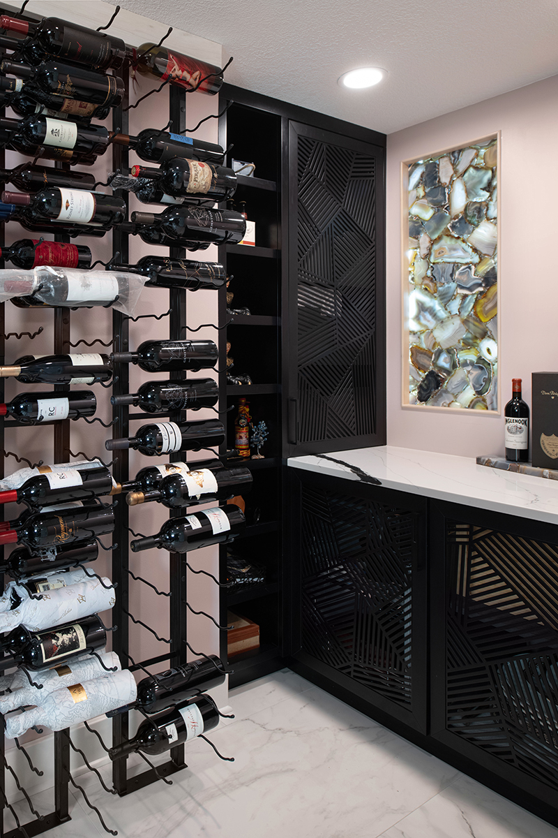 Kleweno custom basement bar and wine cellar Floor-to-ceiling wine storage behind glass enclosure in a luxury basement