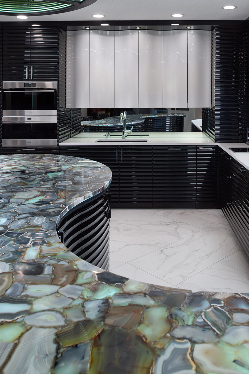 Kleweno custom basement bar and wine cellar Custom home bar featuring a curved island with metallic high-gloss cabinetry