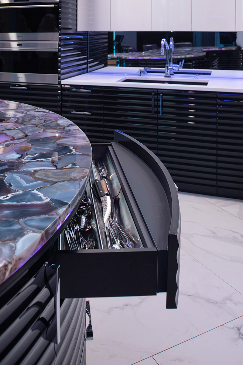 Kleweno custom basement bar and wine cellar Sculptural curved island with illuminated stone front in a luxury basement bar